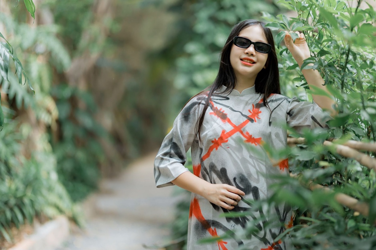 A woman wearing trendy oval sunglasses and a summer linen shirt.