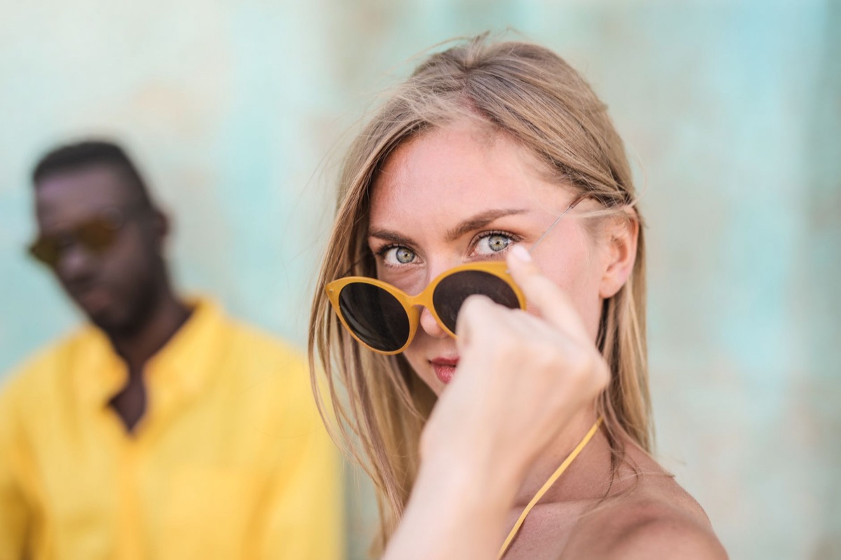 Mujer con gafas de sol ovaladas y camisa de lino