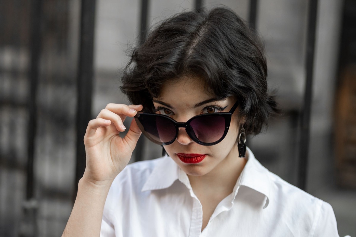 Detalhe de acessórios de moda com óculos de sol e camisa de linho.